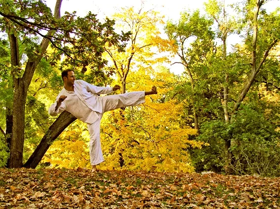 Gregor Chaloupka bei einem Kick in dynamischer Bewegung im herbstlichen Wald