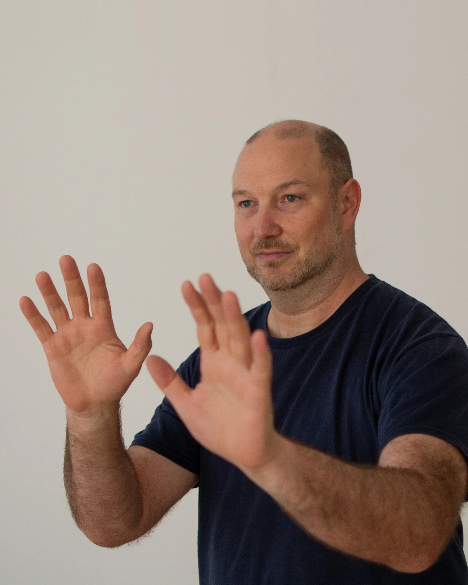 Gregor Chaloupka mit erhobenen, offenen Händen in ruhiger Abwehrhaltung